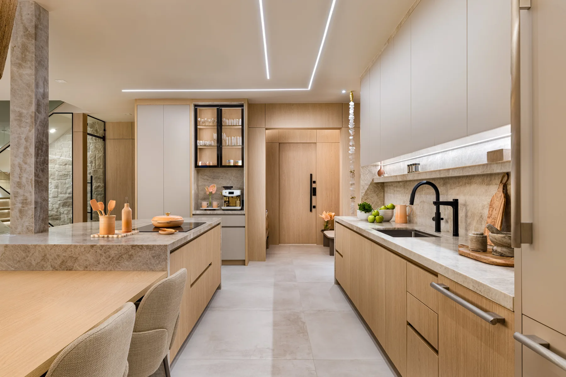 Oak kitchen with a stone island, integrated appliances and a cove-lit ceiling