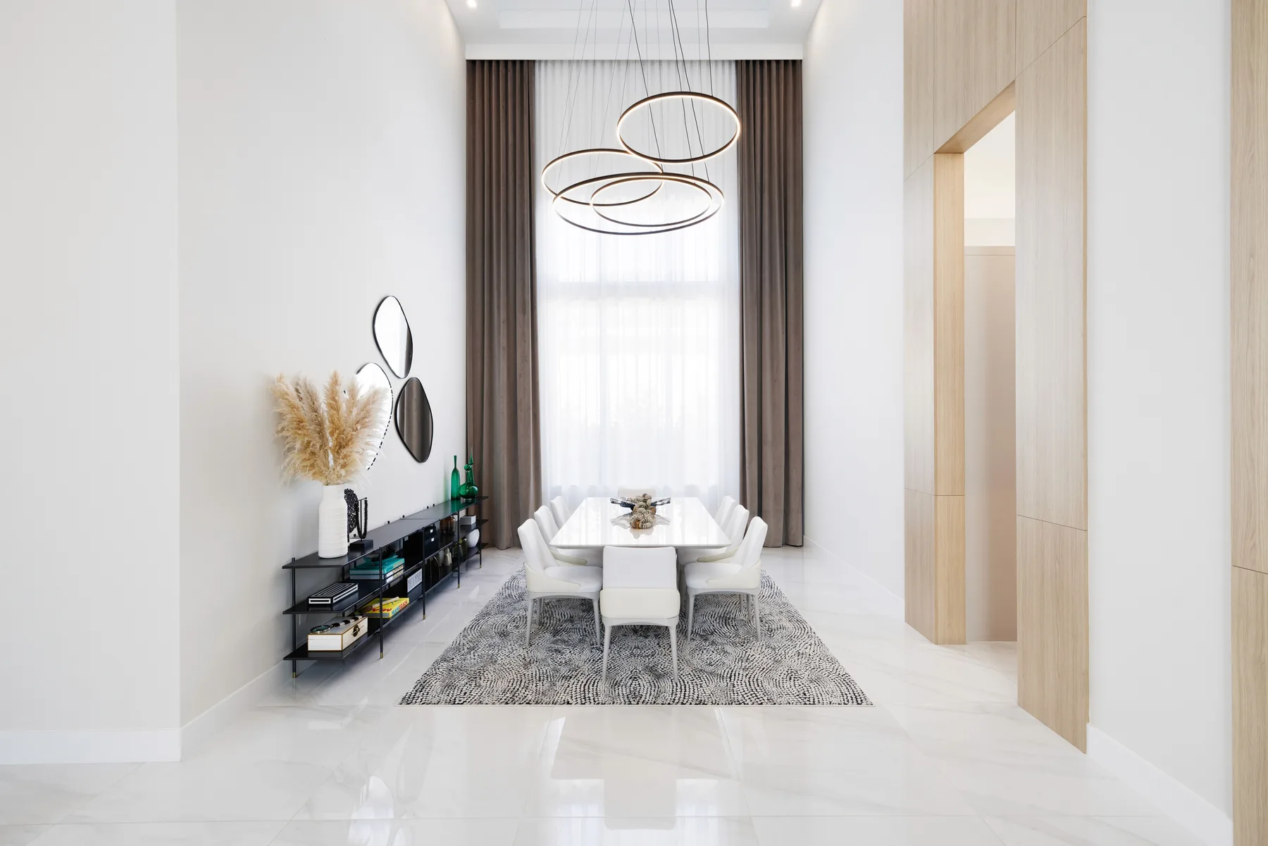 Entry foyer with a sculptural dining chandelier, round mirror and patterned runner