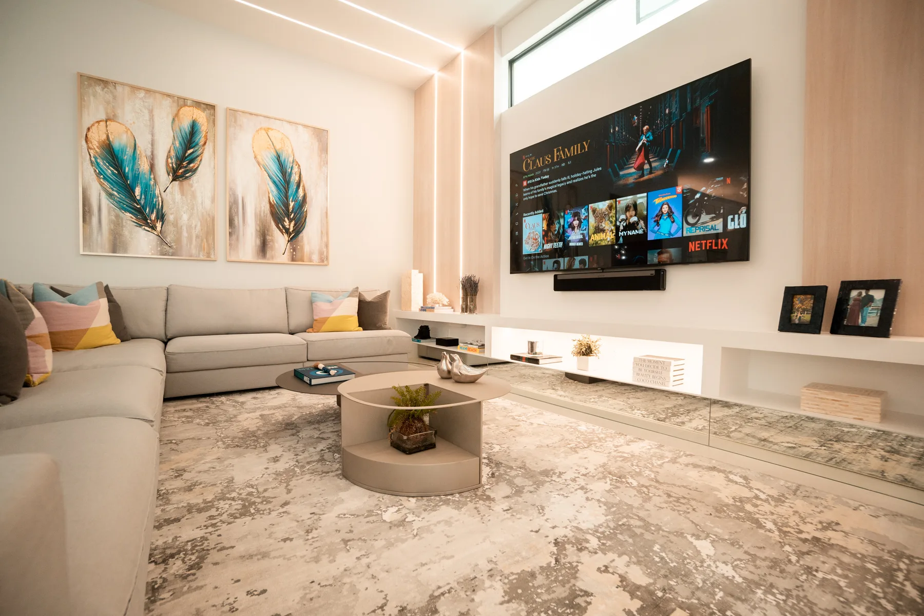 Living room with a marble coffee table, integrated TV wall and a grey sectional