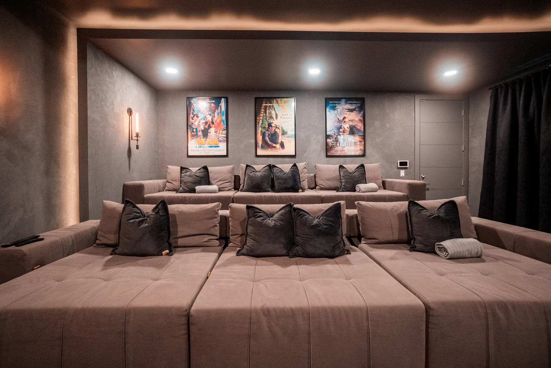 Private cinema with tiered lounge seating, framed artwork and a large projection screen