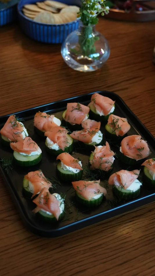 Bites de salmão servidos sobre rodelas de pepino